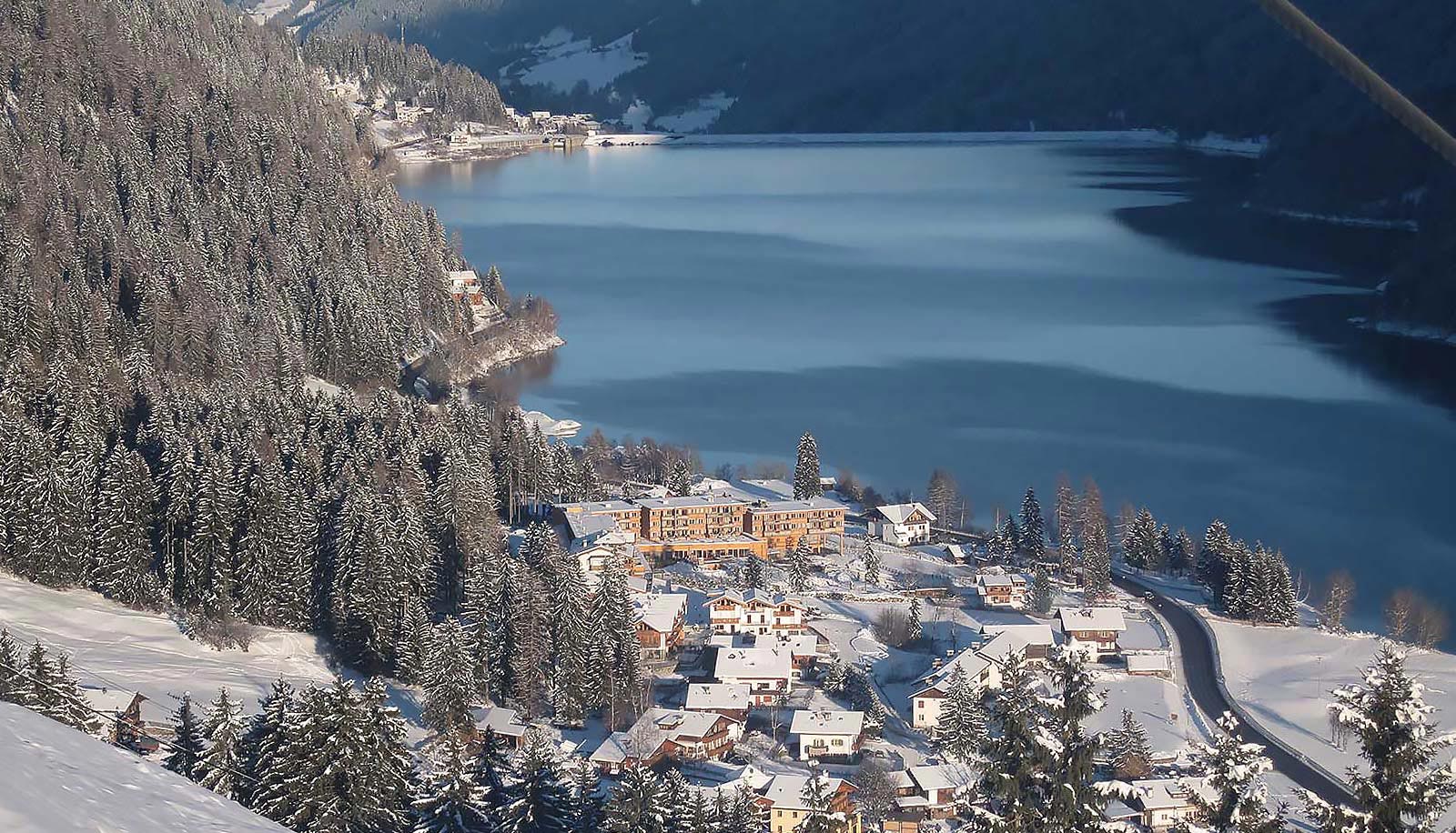 Das verschneite Arosea Hotel im Ultental am Ufer des Zoggler Stausees